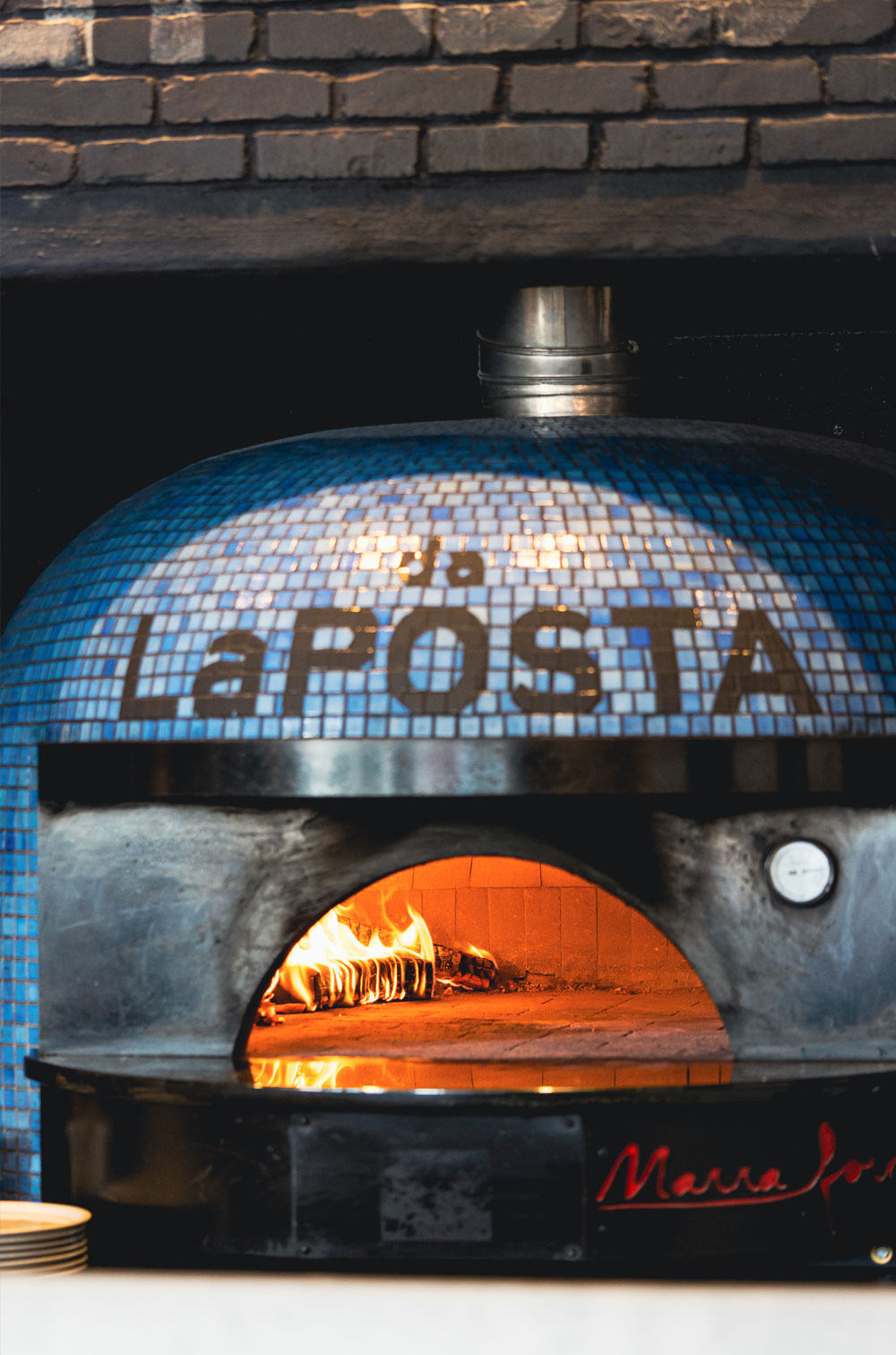 the hand-tiled wood-fired oven at da laposta, with laposta spelled out in mosaic